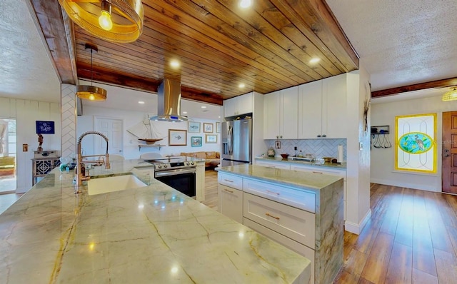 kitchen featuring a sink, extractor fan, beamed ceiling, and stainless steel appliances