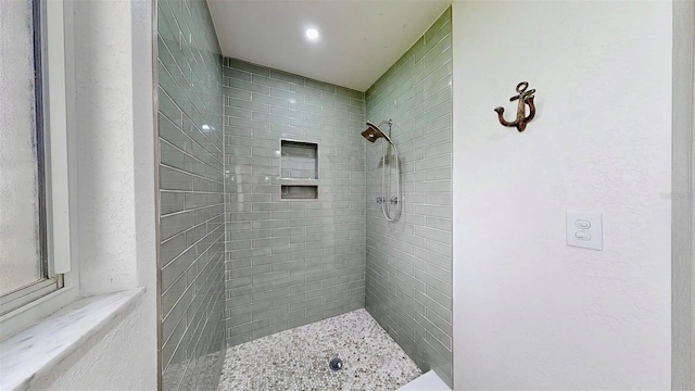 full bathroom with a textured wall and a tile shower