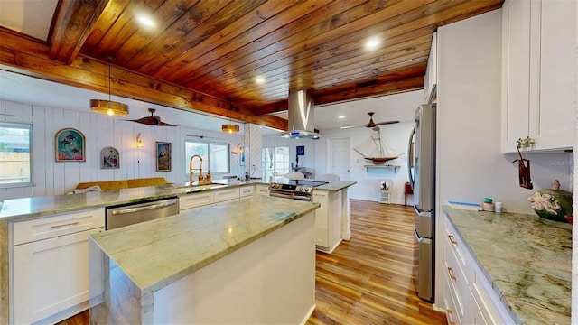 kitchen with light wood finished floors, a sink, stainless steel appliances, a large island, and wood ceiling