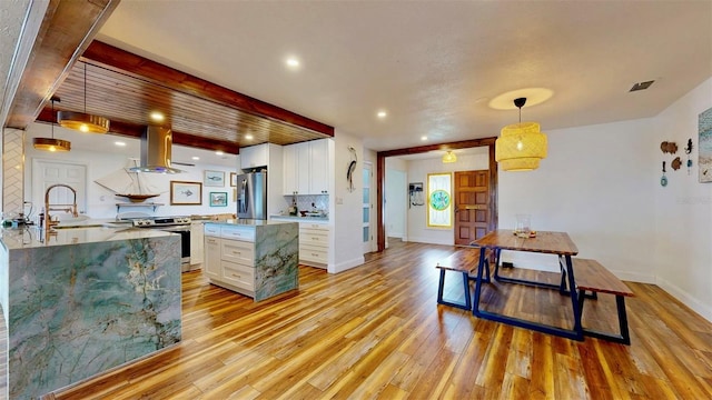 kitchen with light wood-style flooring, a sink, stainless steel appliances, white cabinets, and island range hood