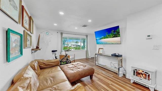 living room with recessed lighting, visible vents, light wood-style flooring, and baseboards