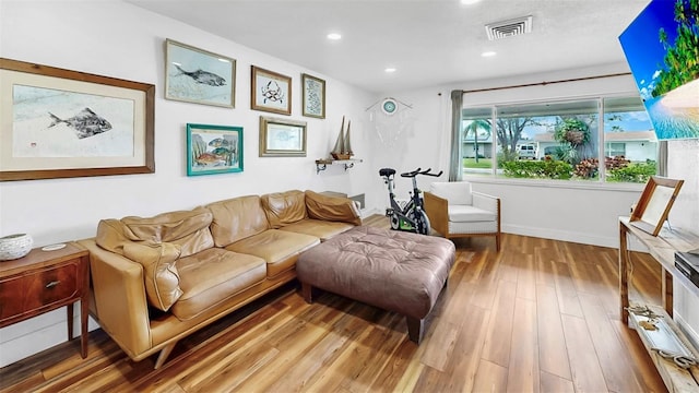 living area with visible vents, recessed lighting, and wood finished floors