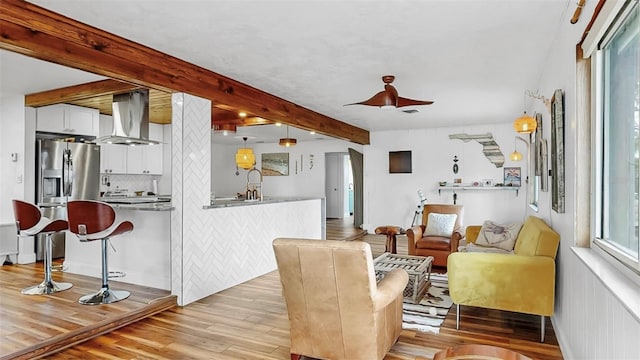 living room featuring beamed ceiling and light wood-style flooring