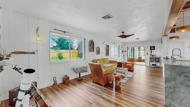 living room with visible vents, light wood-type flooring, and baseboards