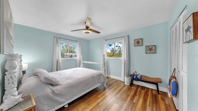 bedroom featuring wood finished floors, baseboards, a closet, and ceiling fan