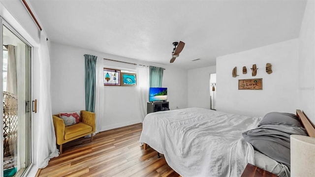 bedroom with visible vents, baseboards, ceiling fan, and wood finished floors