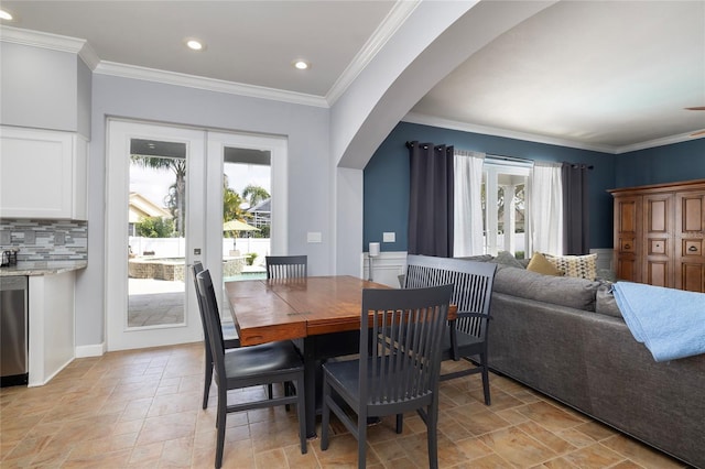 dining room featuring stone finish floor, recessed lighting, arched walkways, and ornamental molding