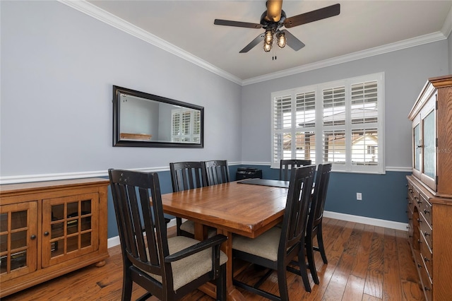 dining room featuring ornamental molding, a ceiling fan, baseboards, and wood-type flooring