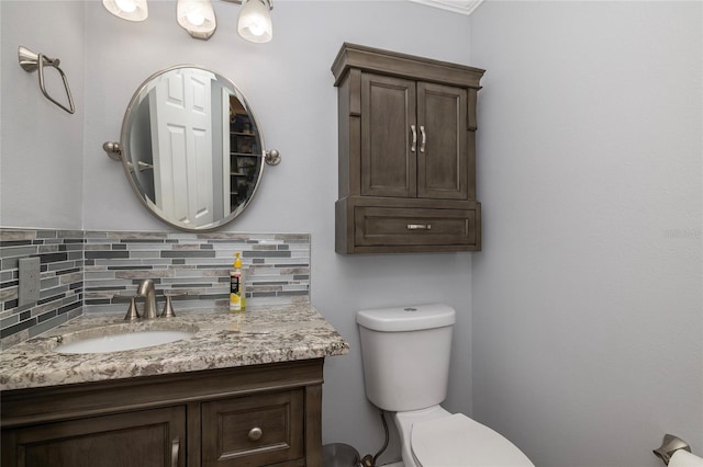 bathroom featuring decorative backsplash, toilet, and vanity