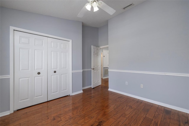 unfurnished bedroom with a ceiling fan, wood finished floors, visible vents, baseboards, and a closet