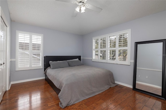 bedroom featuring ceiling fan, baseboards, a closet, a textured ceiling, and wood-type flooring