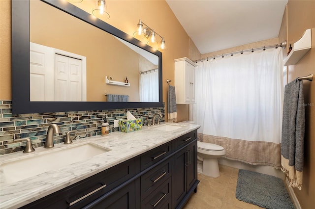 bathroom with a sink, backsplash, tile patterned floors, and toilet