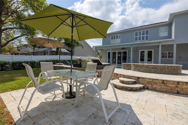 view of patio / terrace featuring outdoor dining area, french doors, a ceiling fan, and fence