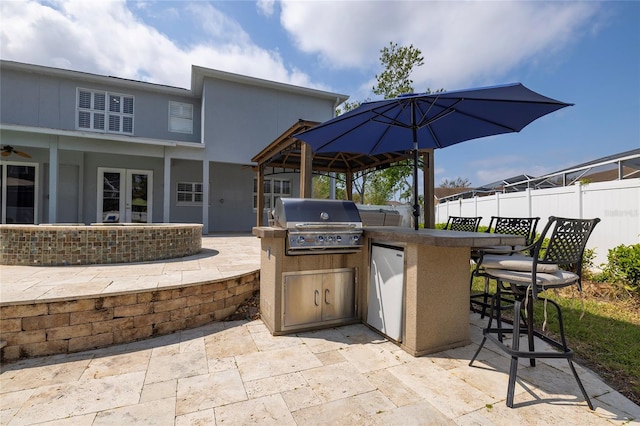 view of patio with outdoor dry bar, fence, exterior kitchen, french doors, and area for grilling