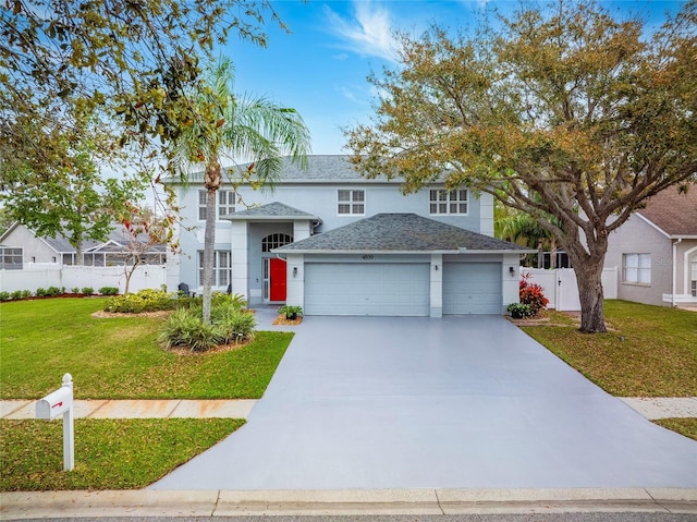 traditional-style home with fence, stucco siding, a front lawn, concrete driveway, and a garage