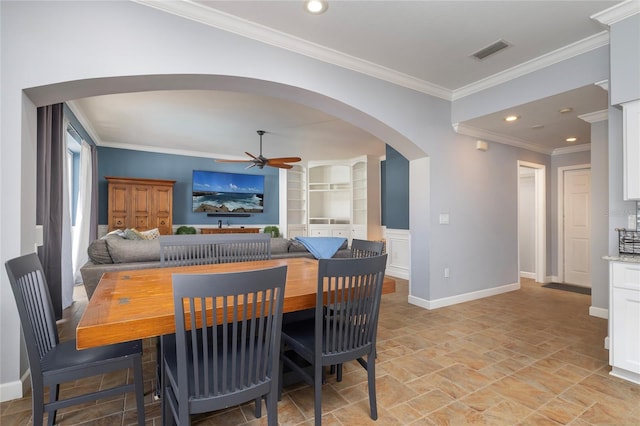 4859 Augusta Ave, Oldsmar, FL 34677 - dining area featuring arched walkways, ceiling fan, built in shelves, light stone finish flooring, and ornamental molding