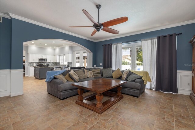 4859 Augusta Ave, Oldsmar, FL 34677 - living room with arched walkways, stone tile floors, ceiling fan, healthy amount of natural light, and ornamental molding
