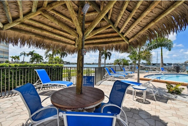 view of patio / terrace with a gazebo, fence, and a community pool