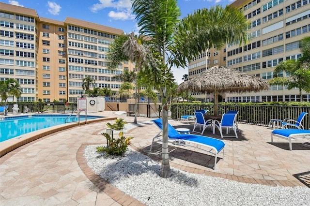 community pool with a patio and fence