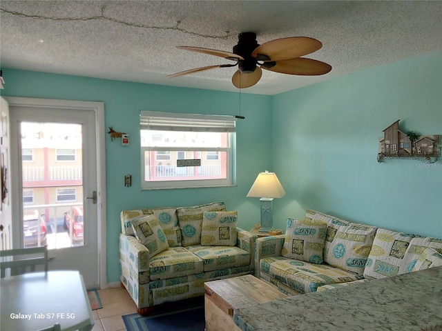 tiled living room featuring ceiling fan and a textured ceiling