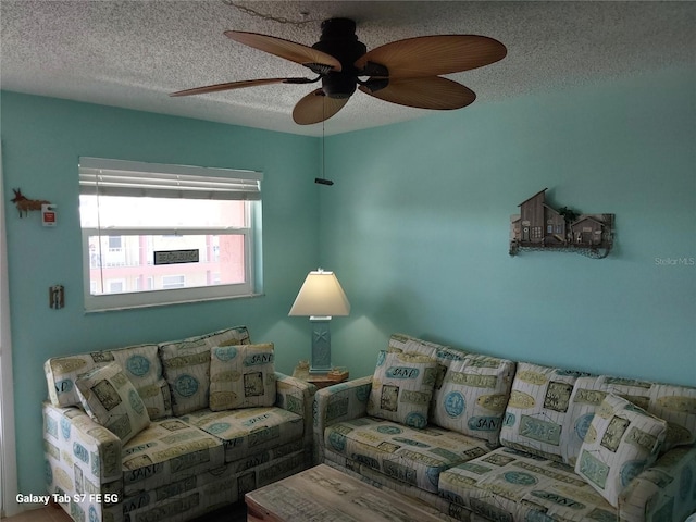 living room featuring a textured ceiling and ceiling fan