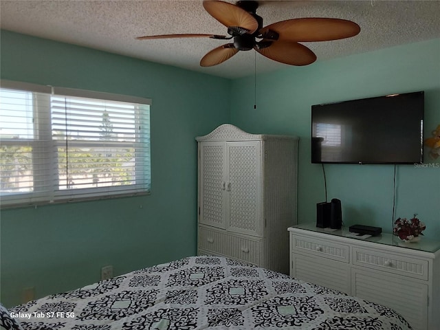 bedroom with a textured ceiling and ceiling fan