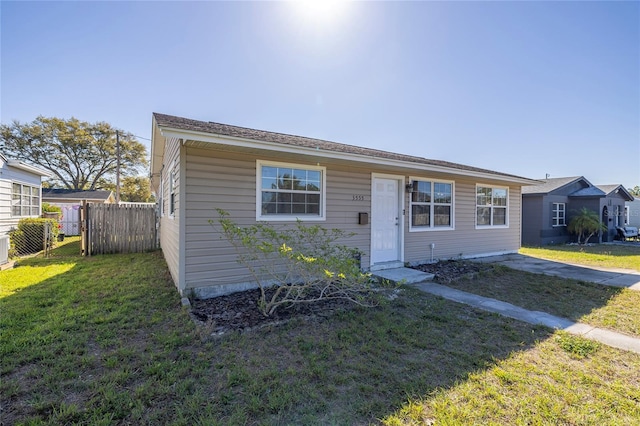 bungalow-style home with a front yard and fence