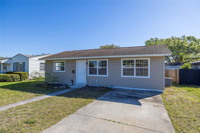 view of front of home featuring a shingled roof, a front lawn, and fence