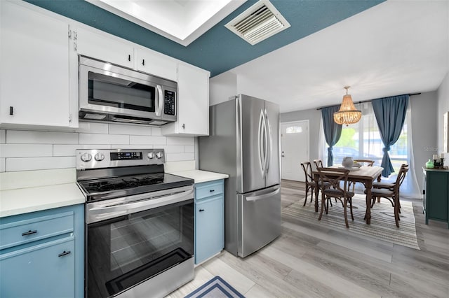 kitchen with visible vents, backsplash, blue cabinetry, light countertops, and stainless steel appliances