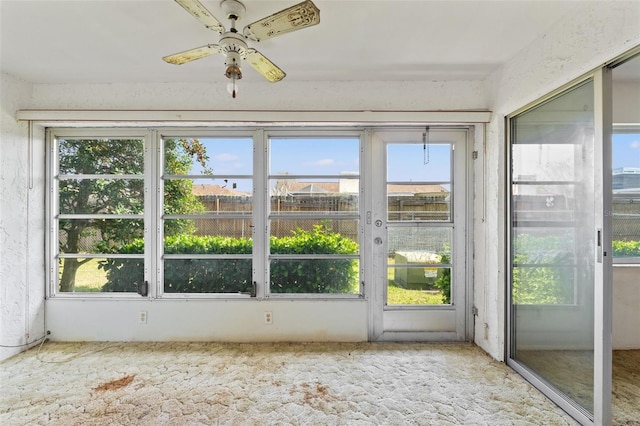 unfurnished sunroom with a wealth of natural light and ceiling fan