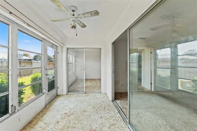 unfurnished sunroom featuring a ceiling fan