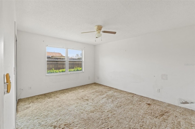 empty room with a textured ceiling, carpet, and a ceiling fan