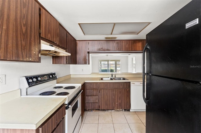 kitchen with white appliances, light countertops, under cabinet range hood, and a sink