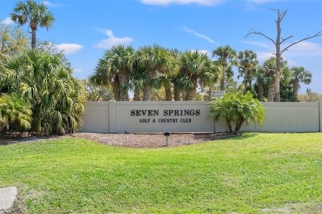 community sign featuring a lawn and fence