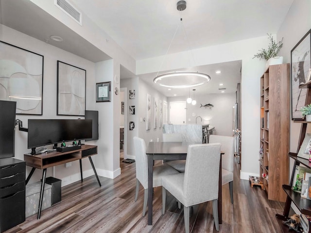 dining area with visible vents, baseboards, and wood finished floors