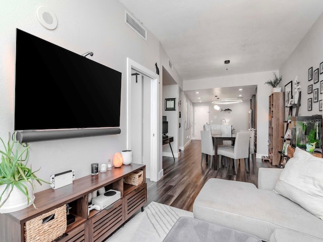 living room with visible vents, baseboards, and wood finished floors