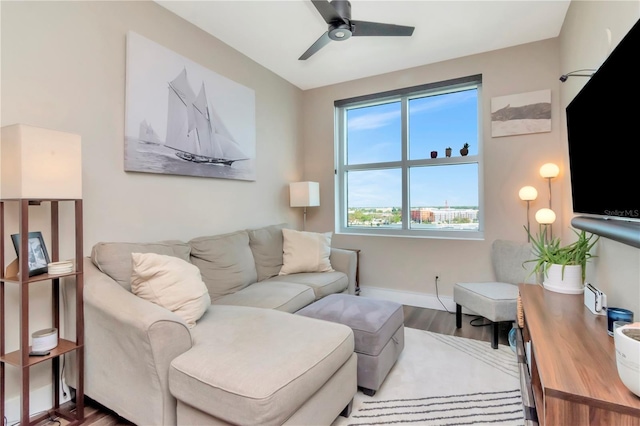 living area featuring a ceiling fan, wood finished floors, and baseboards