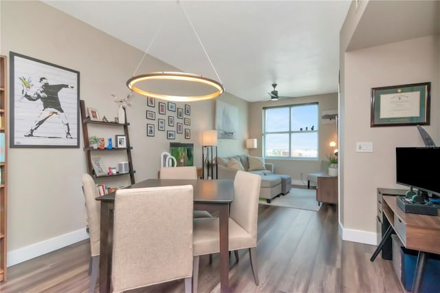 dining space featuring wood finished floors, baseboards, and ceiling fan