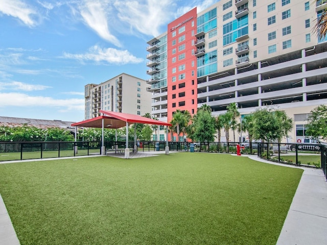 view of property's community featuring a lawn and fence