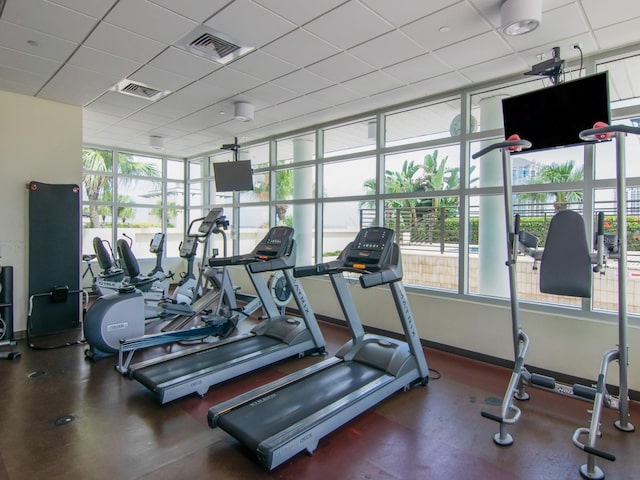 workout area with plenty of natural light, visible vents, and a drop ceiling