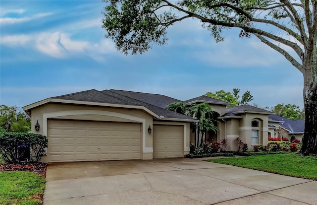 view of front facade featuring roof with shingles, driveway, an attached garage, stucco siding, and a front lawn