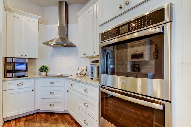 kitchen with wall chimney range hood, dark wood-style flooring, backsplash, and stainless steel appliances