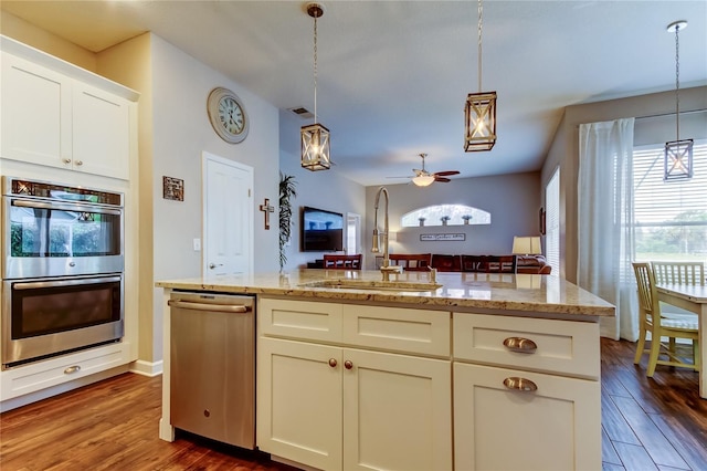 kitchen featuring dark wood-type flooring, appliances with stainless steel finishes, a ceiling fan, and hanging light fixtures