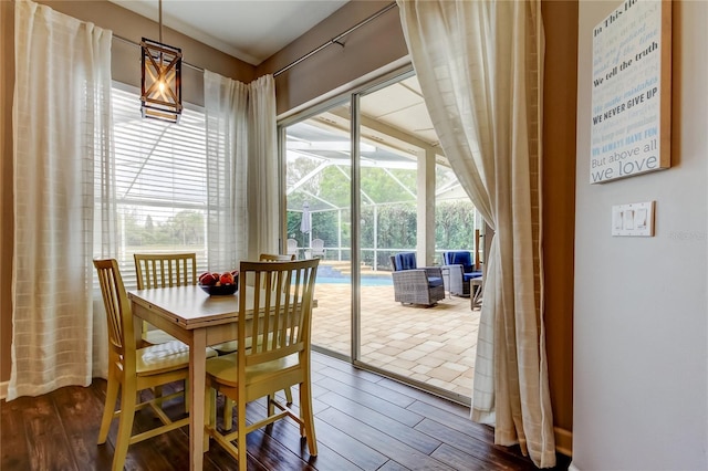 dining space featuring a sunroom and dark wood-style flooring