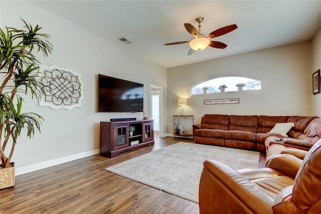 living room with visible vents, baseboards, wood finished floors, and a ceiling fan