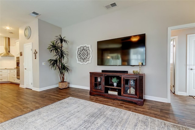 living room featuring visible vents, baseboards, and wood finished floors