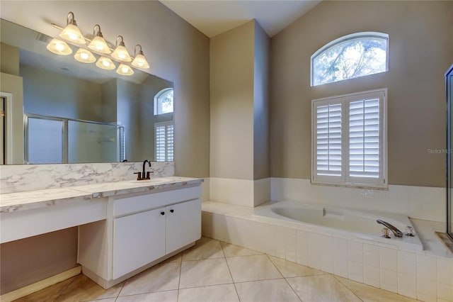 bathroom featuring vanity, a garden tub, a shower stall, and tile patterned flooring