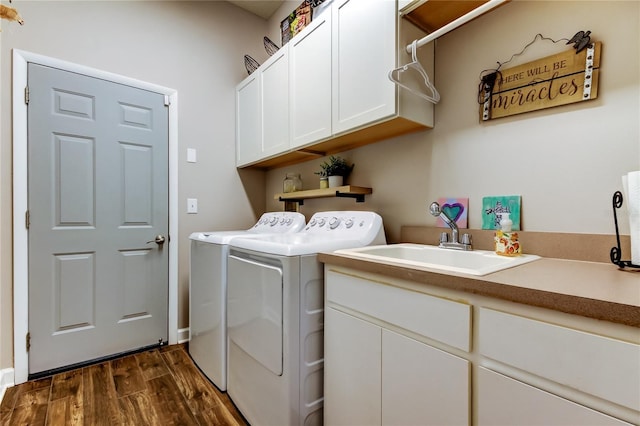 laundry room with cabinet space, washer and dryer, dark wood finished floors, and a sink