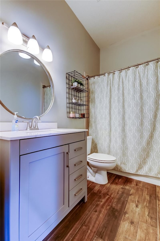 full bath featuring curtained shower, toilet, wood finished floors, and vanity