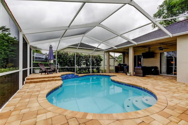 pool featuring glass enclosure, a patio area, and ceiling fan